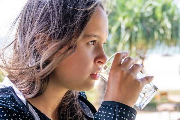 Tween girl drinks glass of water — Stok fotoğraf