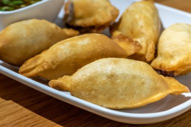 Beyaz tabakta Çin mantısı ve sos.