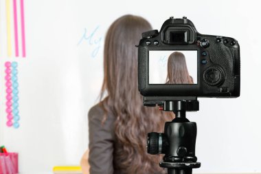 Asya kökenli Amerikalı öğretmen, evde öğrenciler için fotoğraf makinesiyle benim adım beyaz tahtada yazılı.