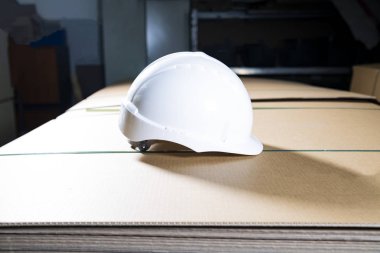 Bir yığın kutunun üzerinde beyaz bir şapka.