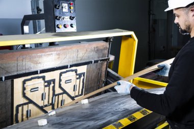 Kağıt kesme makinesi operatörü çalışırken öldü. Yumruk makinesine bir karton koymak. Karton kutu fabrikası.. 