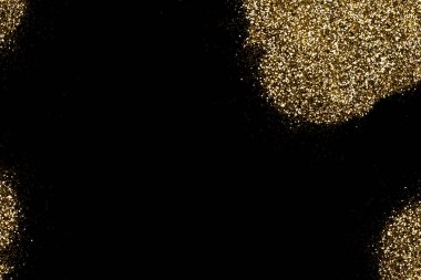 Koyu siyah bir yüzeye saçılmış altın parıltı. Noel, yeni yıl, doğum günü, özel durumlar arka planı, fotokopi alanı olan.