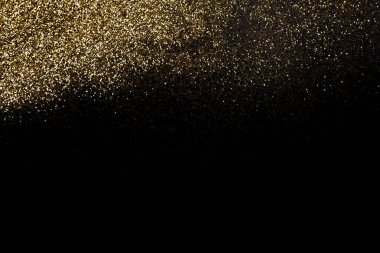 Koyu siyah bir yüzeye dağılmış altın parıltı. Noel, yeni yıl, doğum günü, özel durumlar arka planı, fotokopi alanı olan.