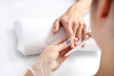 Güzellik salonunda tırnaklarını kesen bir kadın. Manikür