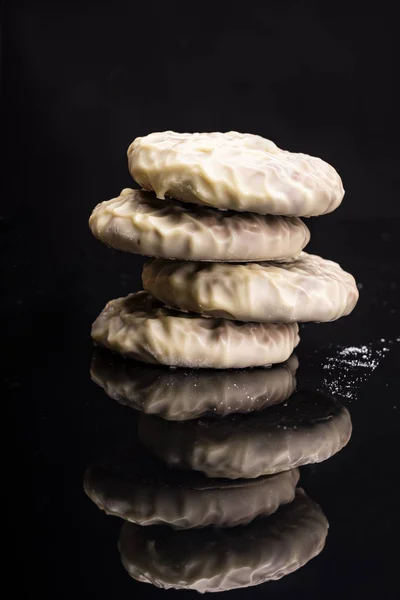 Cookies with white chocolate coating, isolated on a black background.