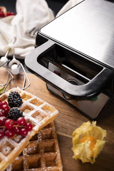 Waffles recém-assados, frutas e um ferro waffle profissional — Fotografia de Stock