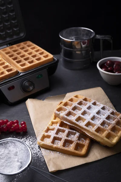 Classic golden waffles with powdered sugar in a composition on stony worktop — Stock Photo, Image