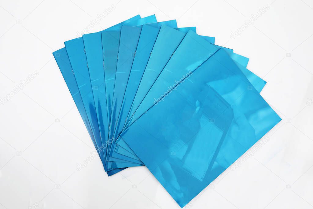 Blue, fanned out, advertising folders isolated on white background, with a copyspace.