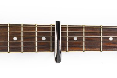 Klasik akustik gitardan oluşan bir fretboard üzerinde beyaz bir zemin, yakın plan, üst görünüm.