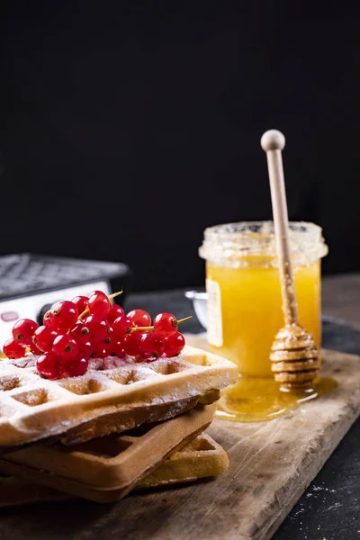 Stack of freshly baked waffles decorated with fruits, powdered sugar and honey — Stock Photo, Image