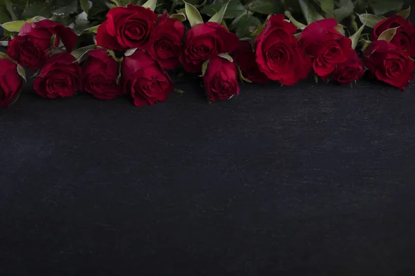 Valentine Day frame. Red roses on the upper edge on a dark background with  a copyspace - Stock Image - Everypixel