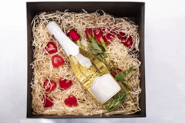 Gift box - red roses, hearts, champagne isolated on white. Valentine\'s Day.