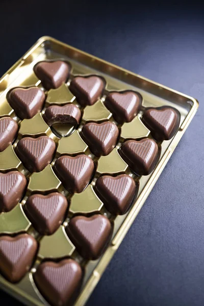Valentine\'s Day gift, sweets. Box of heart-shaped chocolates on a black background.