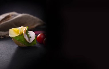 Çıtır ekmekten yapılmış küçük bir iştah açıcı sandviç, kümes hayvanları için soğuk kesim, sert peynir, marul ve soğanlı. Siyah taşlı bir atölyede parmak yiyeceği, kopyalama alanı ve metin alanı olan pankart.