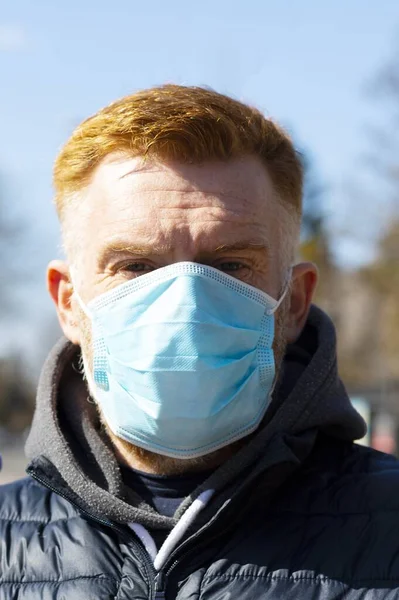 一个戴着外科口罩站在室外的男人。Coronavirus感染防护包迅速传播日冕大流行病. — 图库照片