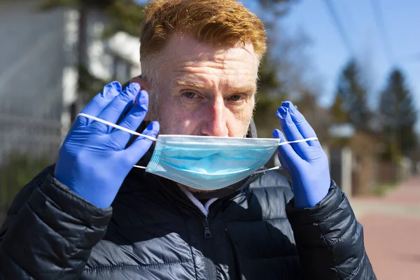 Homem Ruivo Luvas Proteção Colocando Uma Máscara Facial Livre Dia — Fotografia de Stock