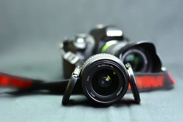 Siyah kamera, gri arka plan lensine yakın plan.