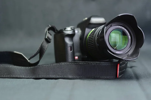 Gri arkaplandaki siyah kamera.