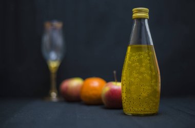 Cam şişedeki sarı içecek.