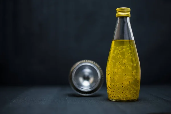 Cam şişedeki sarı içecek.