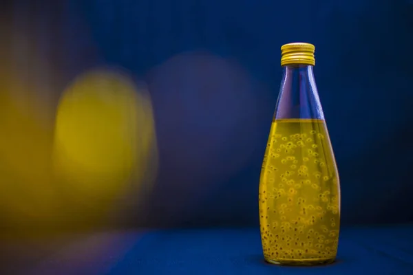 Cam şişedeki sarı içecek.