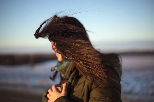 Siyah saçlı kız saçlarını rüzgârda dağıttı.