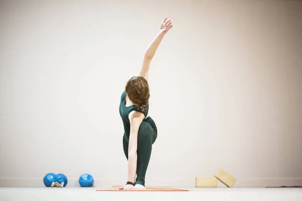 Kız beyaz bir stüdyoda yoga yapıyor.