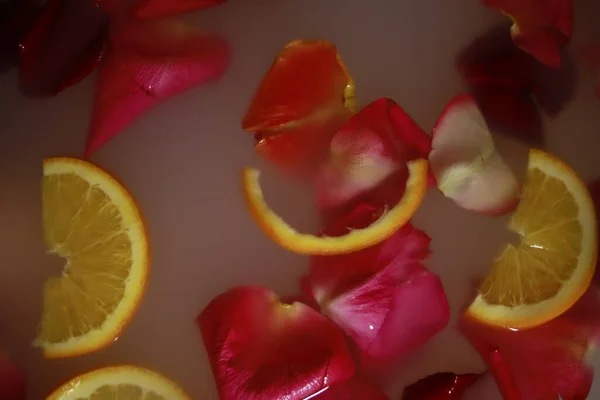 rose petals and oranges in water