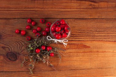 Dokunulmazlık artırıcı tedaviler, aşılar. Doğal kekik, nane ve gül üzümleri bir kavanozda ahşap bir arka planda..