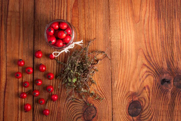 Immunity boosting treatments, infusions. Natural thyme, mint herbs and rosehip berries in a jar on a wooden background. — Stock Photo, Image