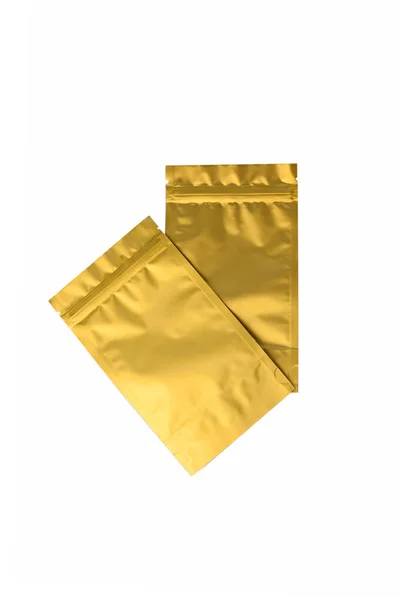 Bolsa metalizada dourada fot chá e café isolado no fundo branco. Modelo de embalagem vazio em branco da folha mockup . — Fotografia de Stock