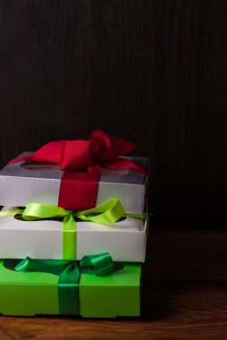 Kahverengi ahşap arka planda kurdeleli renkli hediye kutuları. Tatiller, Noel, yeni yıl hediyeleri..