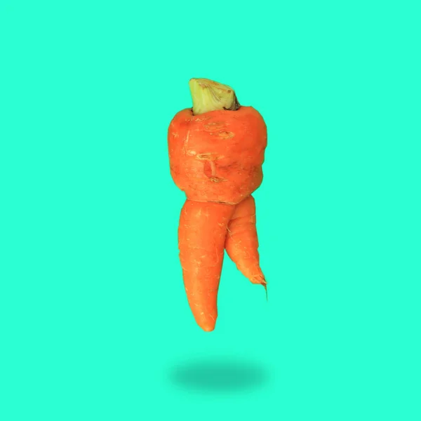 Уродливая еда. Deformed carrots on trendy aqua turquoise background.Food waste problem concept.Minimal flatlay, pop art style — стоковое фото