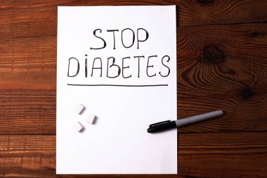 Şeker Hastalığını Durdur, beyaz kağıt üzerinde şeker küpleri ile birlikte...