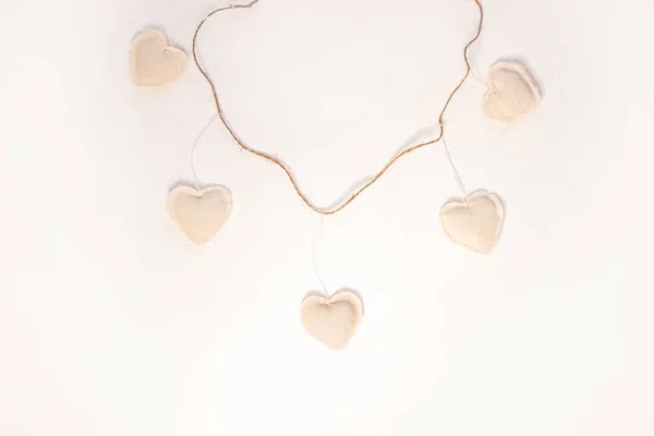 Coeurs en tissu éco lin sur fond bois, conception de concept Saint Valentin.Coeur blanc décoratif sur guirlande de ficelle de jute . — Photo