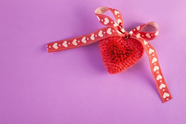 Mor arka planda pembe işlemeli kalp, yaratıcı minimum konsept. Sevgililer günü kartı, fotokopi alanı, sosyal medya afişi.