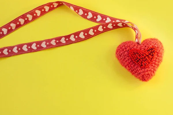 Coeur tricoté rose sur fond jaune flatlay, concept minimal créatif.Carte de Saint-Valentin, espace de copie, bannière de médias sociaux — Photo