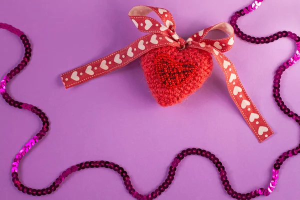 Coeur tricoté rose sur fond violet flatlay, concept minimal créatif.Carte de Saint-Valentin, espace de copie, bannière de médias sociaux — Photo