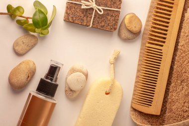 Spa ve sağlık konsepti, doğal kahve fırçası sabun, yağ kozmetik spreyi, soyulmuş kum taşı, havlu, doğal ahşap tarak.