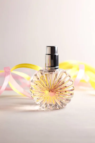 Perfume bottle on light background. Blank perfumery mockup, spa branding concept. Glamour fragrance, eau de parfum