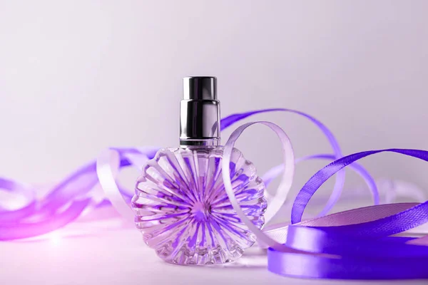 Perfume bottle on light background. Blank perfumery mockup, spa branding concept. Glamour fragrance, eau de parfum