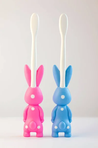 Children's toothbrushes in a form of cute bunnies on a white background isolated. Two rabbits with blank heart. — Stock Photo, Image