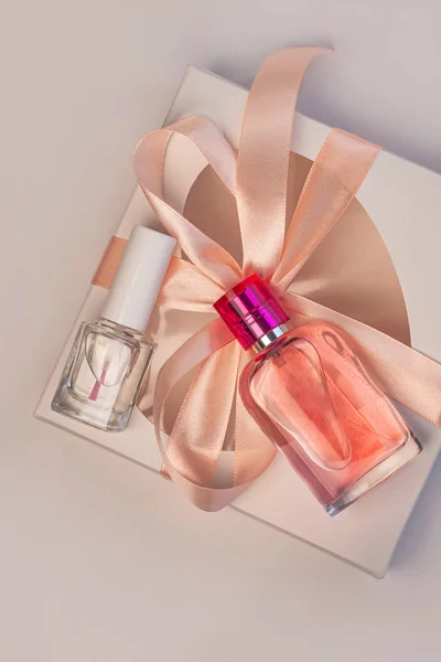 San Valentín concepto creativo flatlay.Gift caja maqueta, botella de perfume rosa, esmalte de uñas con cinta sobre fondo blanco —  Fotos de Stock