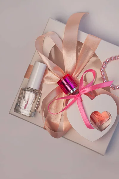 Walentynki kreatywne pojęcie flatlay.Gift box makieta, różowe perfumy butelka, lakier do paznokci z wstążką na białym tle — Zdjęcie stockowe