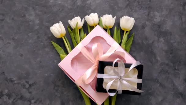 白色郁金香花 黑色和粉色礼品盒 深色背景平坦 4K视频顶视图 3月8日快乐女性母亲节的概念 女性博客广告 — 图库视频影像
