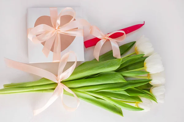 White tulips, gift box with pink candle and ribbon bow on light background flat lay. Text place 8 March Happy Mothers Day Sales.Bouquet greeting card. Copy space banner.Spring website header template.