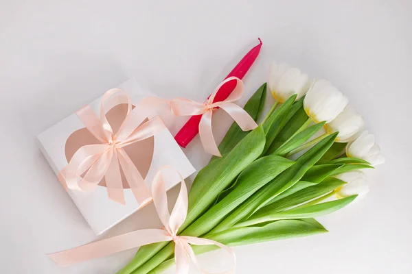 White tulips, gift box with pink candle and ribbon bow on light background flat lay. Text place 8 March Happy Mothers Day Sales.Bouquet greeting card. Copy space banner.Spring website header template.