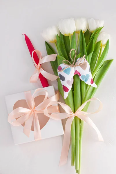 White tulips, gift box with pink candle ribbon bow on light background flat lay. Text place 8 March Happy Mothers Day Sale. Spring bouquet greeting card. Copy space banner. Wedding invitation template