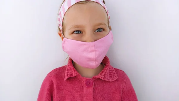 Klein Meisje Hoofdband Met Een Beschermend Roze Stofmasker Tegen Het — Stockfoto