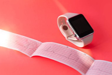 Smart watch on white sports silicone band, ECG diagram paper on pink coral background. Cardiogram medical examination. Prevent hearts disease, mitral valve prolapse syndrome.Analyze people heart rate. clipart